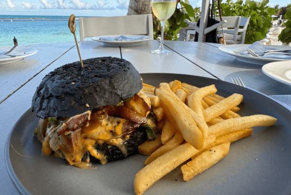 black bun burger on table with ocean view